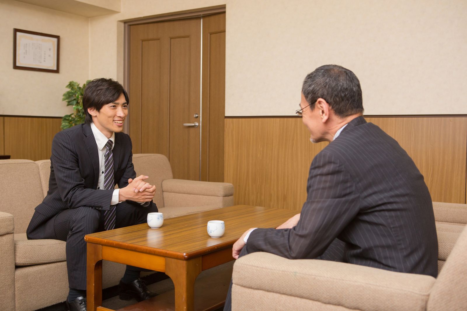 応接室で向き合って話すビジネスパーソンと社長