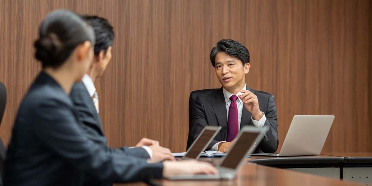 真剣な表情で並ぶ3人のビジネスパーソン